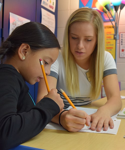 Briar Cliff student teacher working with younger student on homework.