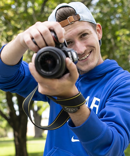 Male student looking into his camera.