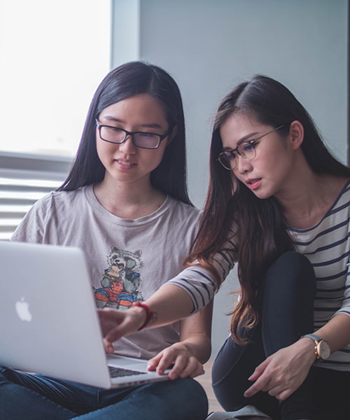 Two female students looking at computer. 