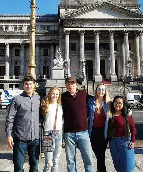 Students and professor standing outside building in Argentina