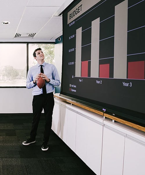 Male giving company presentation while holding football.