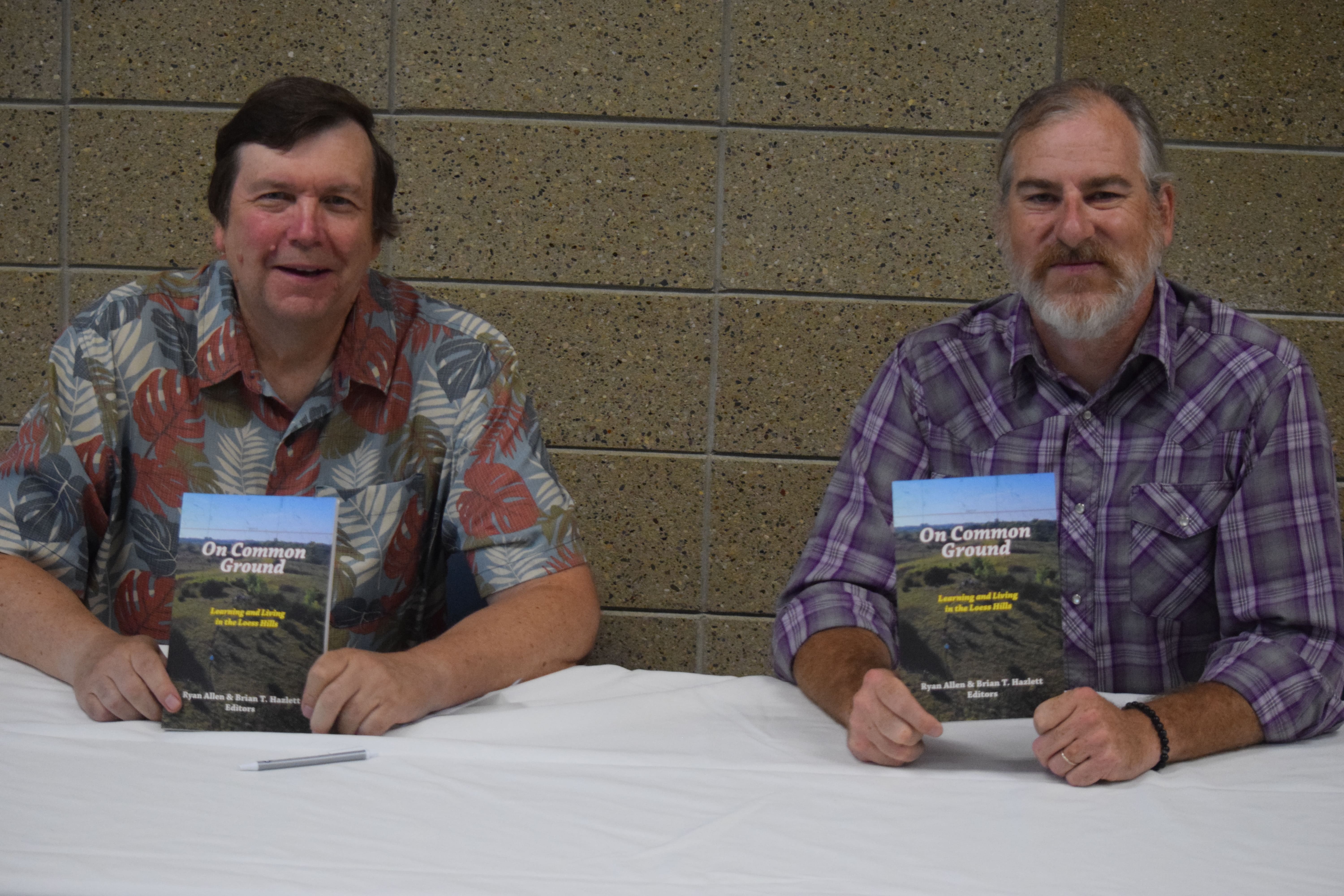 Bryan Hazlett and Ryan Allen holding a copy of On Commo